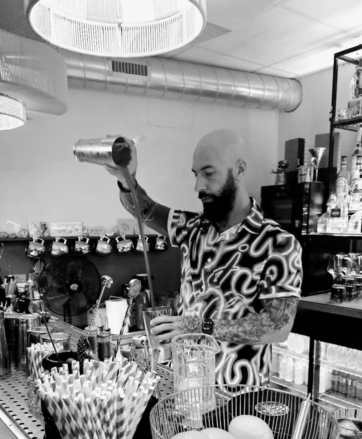 Bartender vertiendo un cóctel con jigger de cobre